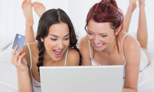 Two women shop online.